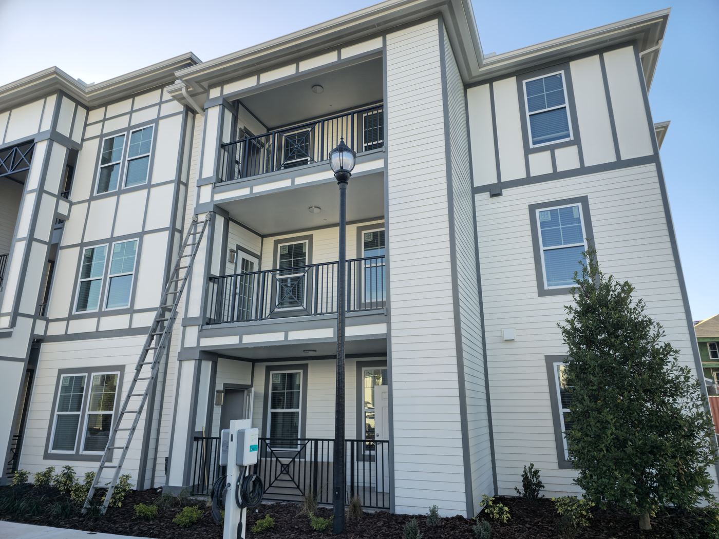 Multifamily building with white fiber-cement siding and dark trim