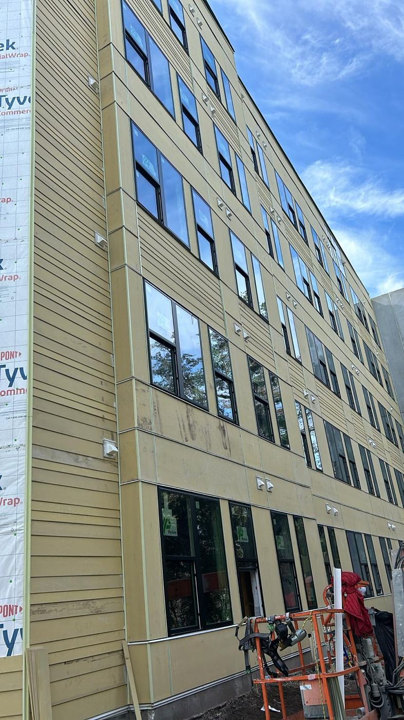 Multistory building with house wrap and siding