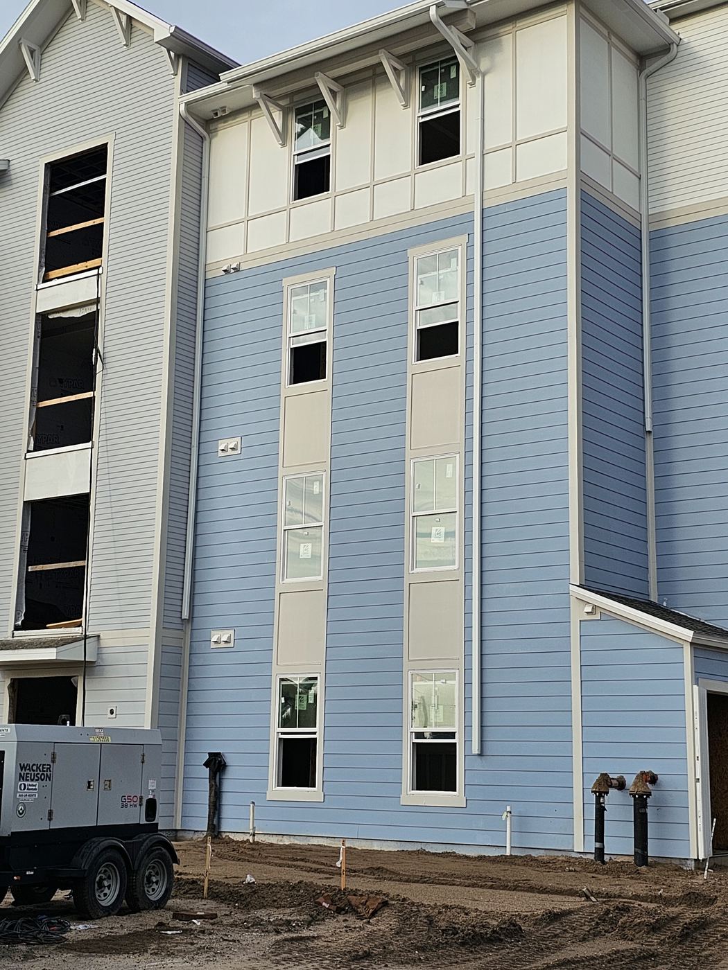 Multistory building with blue siding in progress